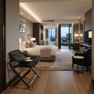 Foldable luggage rack with an open suitcase set up inside a luxury hotel guest bedroom