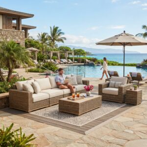 Luxury rattan patio sofas modular outdoor seating on hotel sea-view terrace with a man reading and a woman walking by the pool